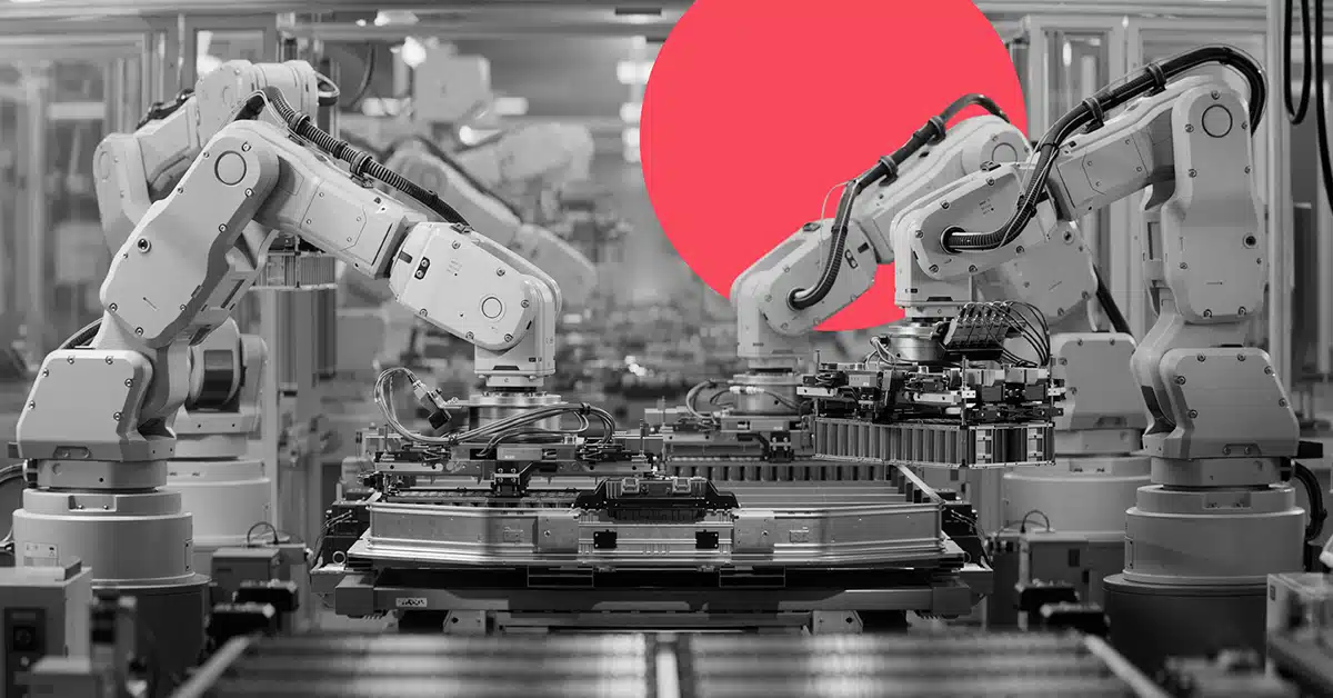 Two mechanical factory robots assemble components in a manufacturing setting.